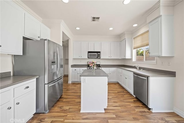 40225 Watford Way, Palmdale, CA 93551 - kitchen featuring appliances with stainless steel finishes, a kitchen island, white cabinetry, recessed lighting, and crown molding