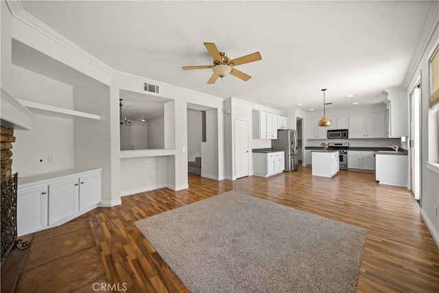 40225 Watford Way, Palmdale, CA 93551 - unfurnished living room with a ceiling fan, dark wood finished floors, ornamental molding, a fireplace, and built in shelves