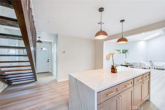 1478 N Park Ave, Pomona, CA 91768 - kitchen featuring light wood finished floors, hanging light fixtures, light stone countertops, and open floor plan