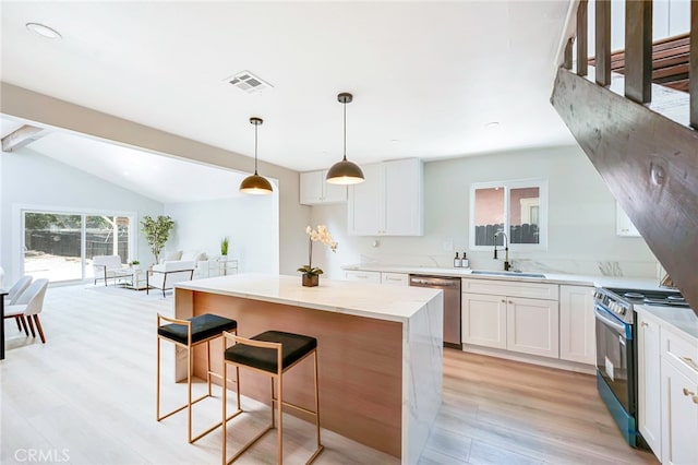 1478 N Park Ave, Pomona, CA 91768 - kitchen with appliances with stainless steel finishes, light wood-type flooring, white cabinetry, and a breakfast bar