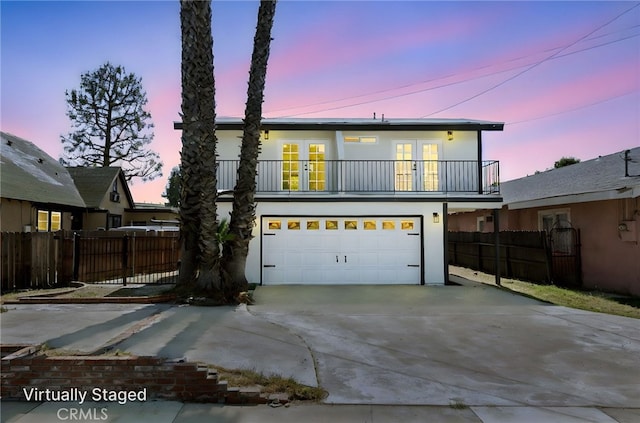 1478 N Park Ave, Pomona, CA 91768 - view of front facade with french doors, a balcony, concrete driveway, an attached garage, and stucco siding