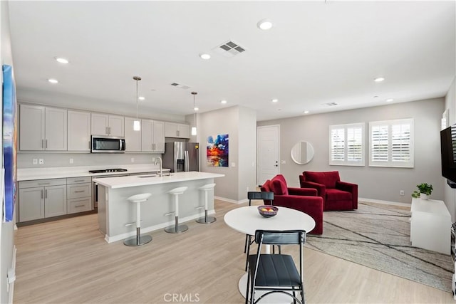 27753 Dyer Way, Canyon Country, CA 91387 - kitchen with stainless steel appliances, a kitchen bar, recessed lighting, light wood-style floors, and light countertops
