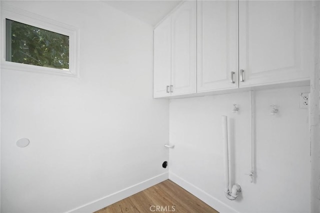 7848 Chastain Ave, Reseda, CA 91335 - laundry room featuring cabinet space and wood finished floors