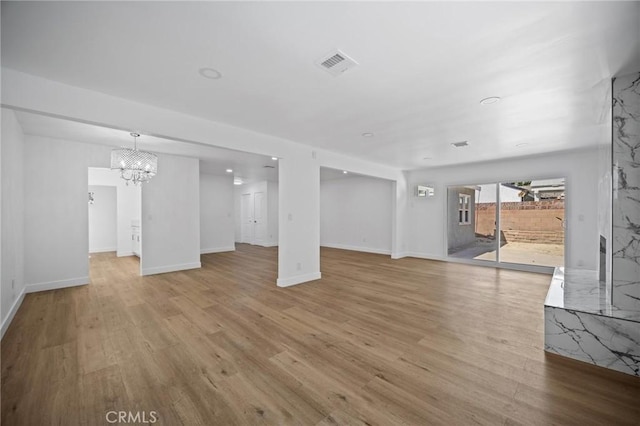 7848 Chastain Ave, Reseda, CA 91335 - unfurnished living room featuring light wood-style floors and a chandelier