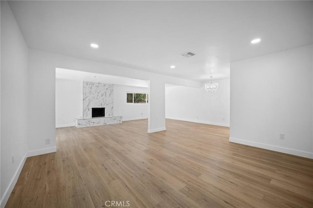 7848 Chastain Ave, Reseda, CA 91335 - unfurnished living room featuring a chandelier, wood finished floors, a high end fireplace, and recessed lighting