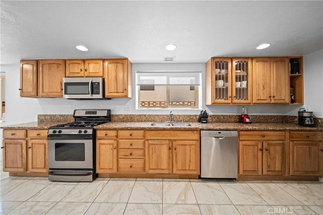 42903 Normandy Ln, Lancaster, CA 93536 - kitchen with stainless steel appliances, light marble finish flooring, dark stone countertops, glass insert cabinets, and recessed lighting