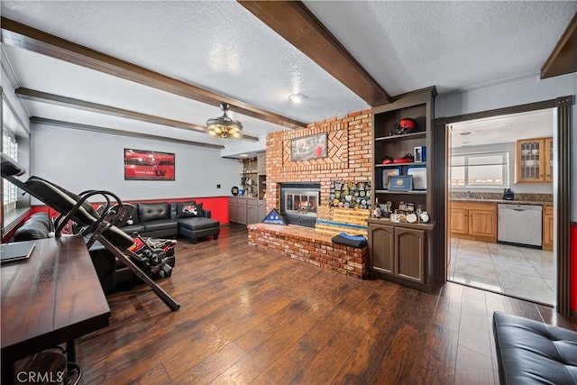 42903 Normandy Ln, Lancaster, CA 93536 - living area featuring a textured ceiling, a fireplace, beamed ceiling, light wood-type flooring, and ceiling fan