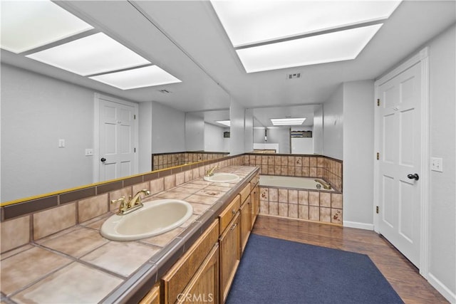 42903 Normandy Ln, Lancaster, CA 93536 - bathroom featuring wood finished floors, double vanity, and a bath