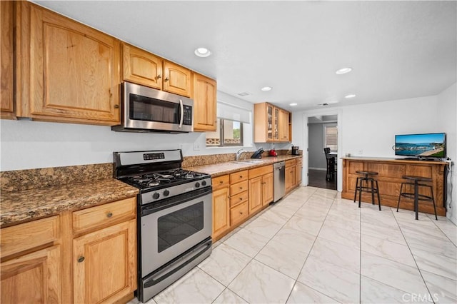 42903 Normandy Ln, Lancaster, CA 93536 - kitchen with stainless steel appliances, light marble finish flooring, recessed lighting, glass insert cabinets, and dark stone countertops