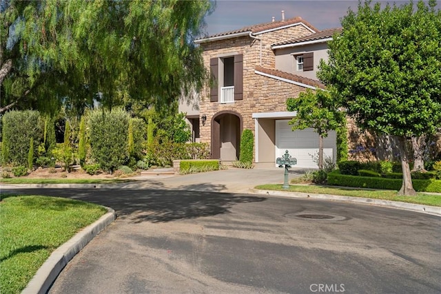 2 Tarascon, Newport Coast, CA 92657 - view of front of home with stone siding, driveway, stucco siding, a tiled roof, and an attached garage