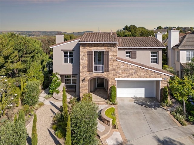 2 Tarascon, Newport Coast, CA 92657 - view of front of property featuring stone siding, a chimney, stucco siding, driveway, and a garage