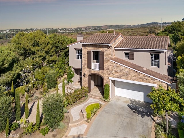 2 Tarascon, Newport Coast, CA 92657 - mediterranean / spanish-style house with a chimney, stone siding, stucco siding, driveway, and a tiled roof
