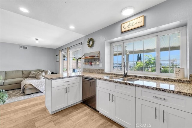 1232 Palos Verde Dr, Corona, CA 92878 - kitchen with dishwashing machine, light wood finished floors, a peninsula, light stone counters, and open floor plan