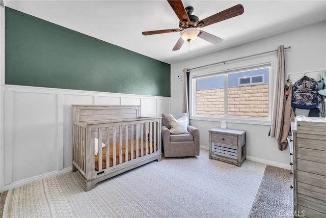 1232 Palos Verde Dr, Corona, CA 92878 - bedroom featuring a nursery area, a wainscoted wall, and ceiling fan