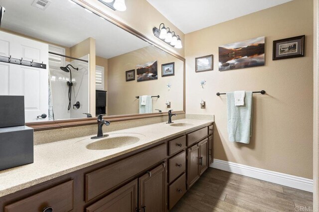 16110 Oak Springs Dr, Ramona, CA 92065 - bathroom featuring double vanity, wood finished floors, and an enclosed shower
