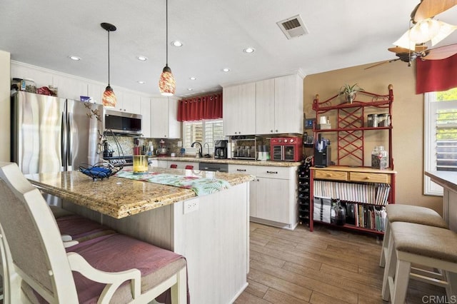 16110 Oak Springs Dr, Ramona, CA 92065 - kitchen featuring appliances with stainless steel finishes, white cabinets, light wood-type flooring, backsplash, and ceiling fan