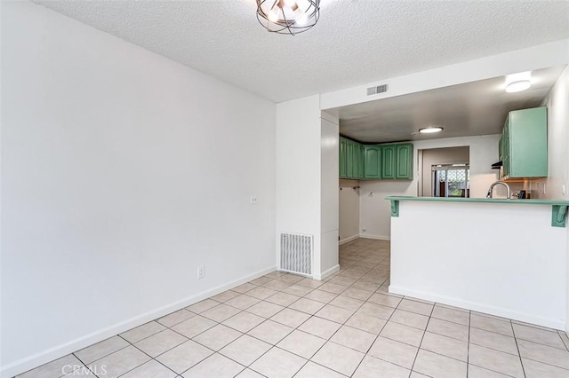4785 Larwin Ave, Cypress, CA 90630 - kitchen featuring green cabinets, a peninsula, light tile patterned floors, and a textured ceiling