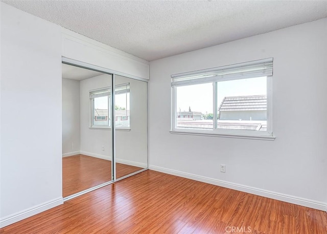 4785 Larwin Ave, Cypress, CA 90630 - unfurnished bedroom featuring light wood-type flooring, a closet, and a textured ceiling