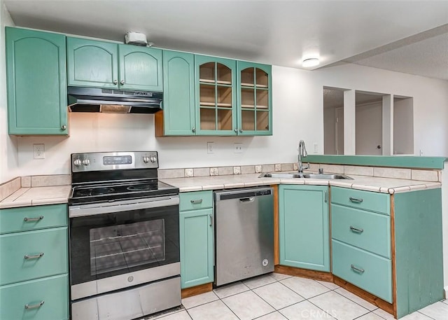 4785 Larwin Ave, Cypress, CA 90630 - kitchen featuring appliances with stainless steel finishes, under cabinet range hood, a peninsula, tile counters, and light tile patterned flooring