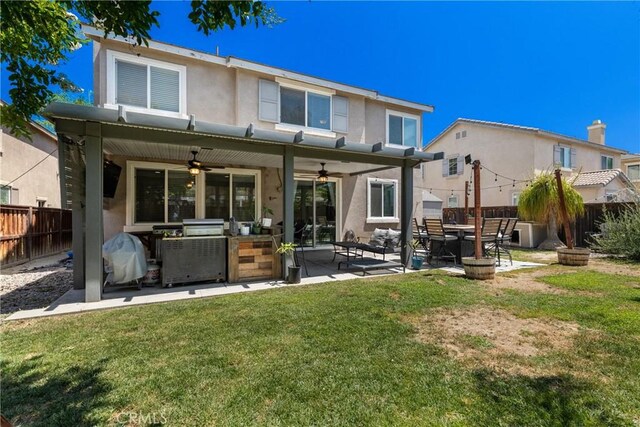 4735 Cassiope Ct, Hemet, CA 92545 - back of house with ceiling fan, a fenced backyard, stucco siding, an outdoor kitchen, and a patio