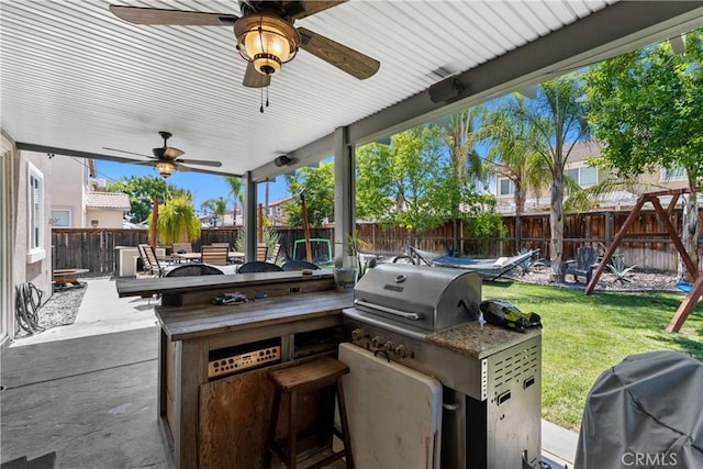 4735 Cassiope Ct, Hemet, CA 92545 - fenced backyard with exterior kitchen, a ceiling fan, a playground, a patio area, and outdoor dining area