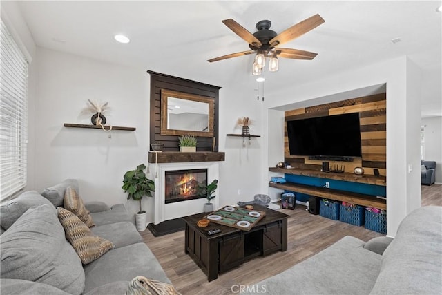 4735 Cassiope Ct, Hemet, CA 92545 - living room with wood finished floors, a ceiling fan, a glass covered fireplace, recessed lighting, and plenty of natural light