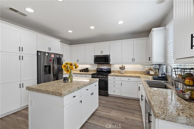 4735 Cassiope Ct, Hemet, CA 92545 - kitchen with stainless steel refrigerator with ice dispenser, gas stove, a kitchen island, white cabinets, and recessed lighting