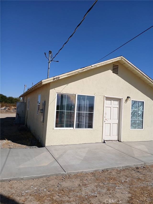 37712 210th St E, Palmdale, CA 93591 - back of house featuring stucco siding and a patio