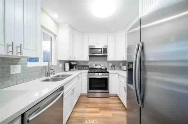 4213 Lonnie St, Oceanside, CA 92056 - kitchen featuring appliances with stainless steel finishes, light wood-type flooring, light countertops, and white cabinets