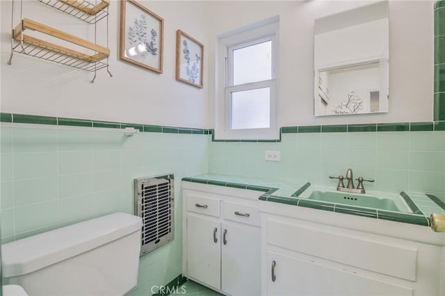 1030 E 2nd St Unit 7, Long Beach, CA 90802 - bathroom featuring tile walls, vanity, heating unit, and wainscoting