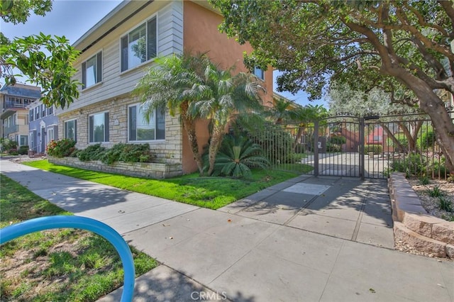 1030 E 2nd St Unit 7, Long Beach, CA 90802 - view of front facade featuring stone siding, a gate, and stucco siding
