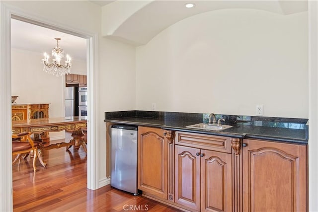6966 Crest Rd, Rancho Palos Verdes, CA 90275 - kitchen featuring stainless steel appliances, a chandelier, wood finished floors, brown cabinets, and pendant lighting