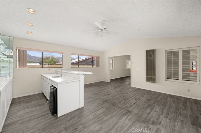43922 Warner Trl, Palm Desert, CA 92211 - kitchen featuring a heating unit, a peninsula, a ceiling fan, dark wood-type flooring, and vaulted ceiling