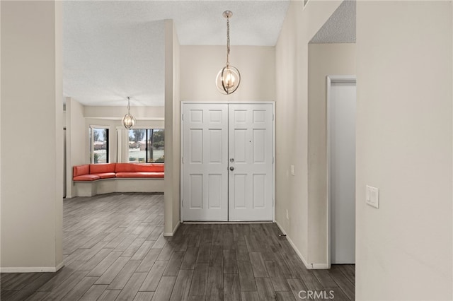 43922 Warner Trl, Palm Desert, CA 92211 - foyer entrance featuring a chandelier, dark wood-style floors, and a textured ceiling