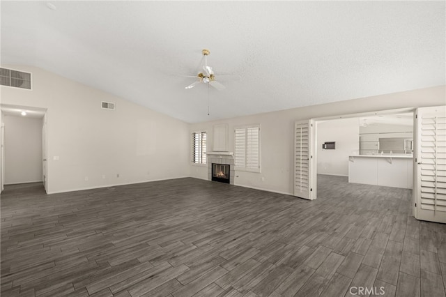43922 Warner Trl, Palm Desert, CA 92211 - unfurnished living room featuring a ceiling fan, lofted ceiling, dark wood-style flooring, and a tiled fireplace