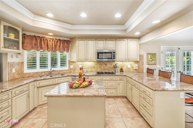 3208 Bridlewood Ct, Bakersfield, CA 93311 - kitchen featuring appliances with stainless steel finishes, cream cabinets, ornamental molding, a raised ceiling, and a peninsula