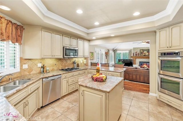 3208 Bridlewood Ct, Bakersfield, CA 93311 - kitchen with appliances with stainless steel finishes, cream cabinets, a raised ceiling, crown molding, and recessed lighting