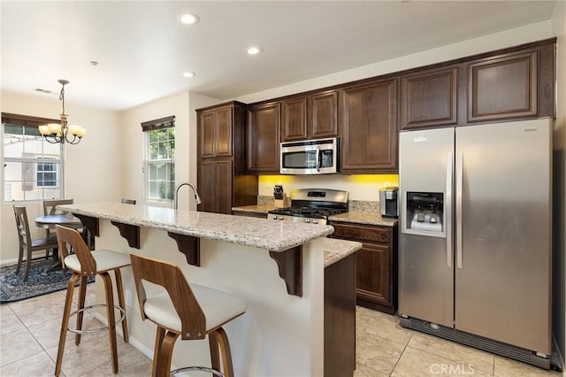 31186 Lavender Ct Unit 164, Temecula, CA 92592 - kitchen featuring appliances with stainless steel finishes, light tile patterned flooring, dark brown cabinets, a kitchen bar, and recessed lighting