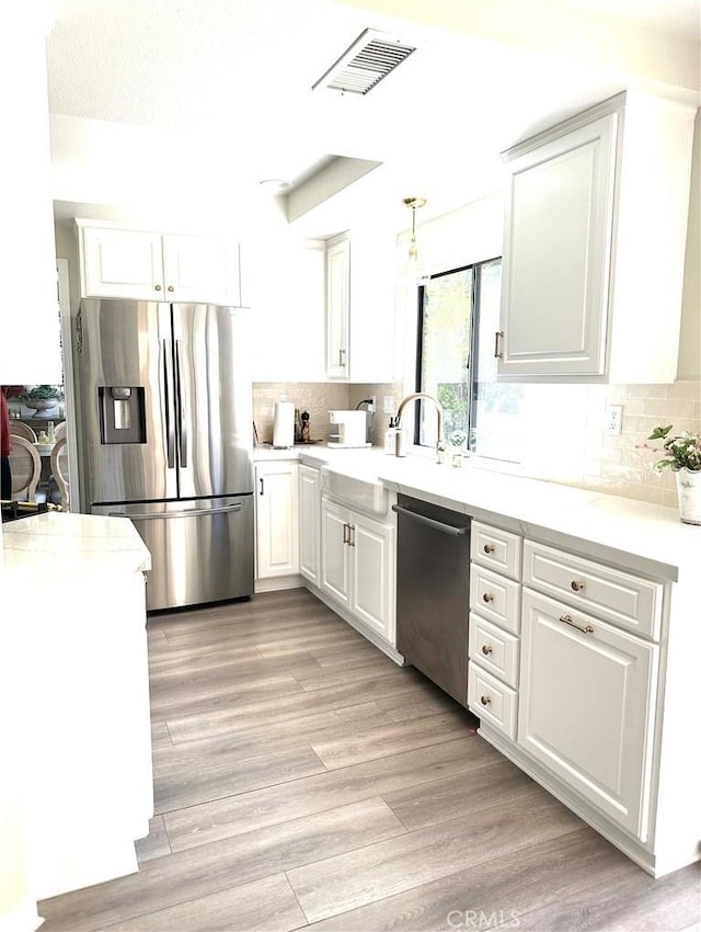 3931 Cottonwood Grove Trl, Calabasas, CA 91301 - kitchen featuring appliances with stainless steel finishes, white cabinets, and backsplash