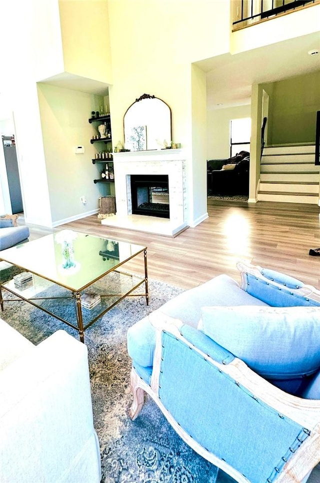 3931 Cottonwood Grove Trl, Calabasas, CA 91301 - living area featuring wood finished floors, a high ceiling, and a glass covered fireplace