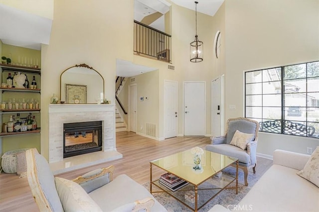 3931 Cottonwood Grove Trl, Calabasas, CA 91301 - living area featuring a glass covered fireplace, wood finished floors, a high ceiling, and stairs