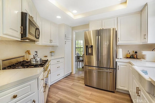 3931 Cottonwood Grove Trl, Calabasas, CA 91301 - kitchen featuring appliances with stainless steel finishes, recessed lighting, white cabinetry, light wood-style floors, and tasteful backsplash