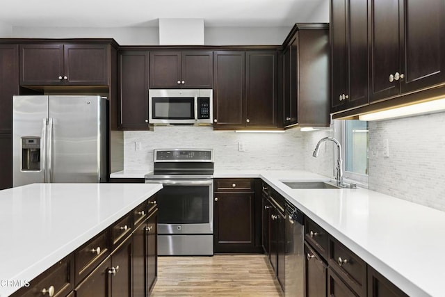 623 W Foothill Blvd Unit 43, Glendora, CA 91741 - kitchen with appliances with stainless steel finishes, light countertops, tasteful backsplash, dark brown cabinets, and light wood-type flooring