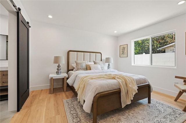 8840 Valjean Ave, North Hills, CA 91343 - bedroom featuring a barn door, light wood-style floors, and recessed lighting