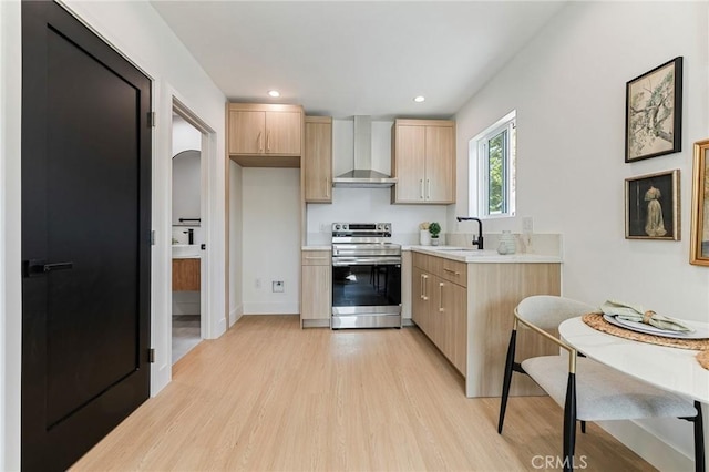 8840 Valjean Ave, North Hills, CA 91343 - kitchen with stainless steel range, wall chimney exhaust hood, light brown cabinets, light wood-style flooring, and light countertops
