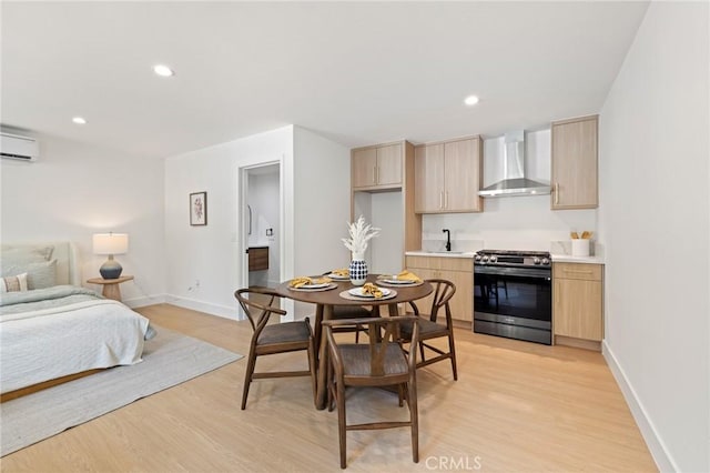 8840 Valjean Ave, North Hills, CA 91343 - kitchen with wall chimney exhaust hood, gas range, light brown cabinetry, a wall mounted AC, and light wood-type flooring