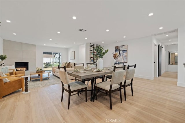 8840 Valjean Ave, North Hills, CA 91343 - dining room with light wood finished floors, recessed lighting, a fireplace, and a barn door