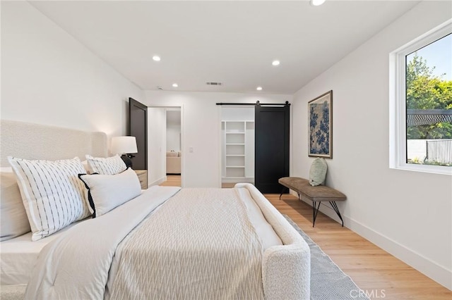 8840 Valjean Ave, North Hills, CA 91343 - bedroom featuring recessed lighting, light wood-type flooring, and a barn door