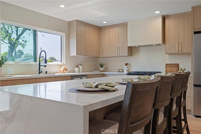 8840 Valjean Ave, North Hills, CA 91343 - kitchen featuring light brown cabinetry, light stone counters, recessed lighting, premium range hood, and a breakfast bar area