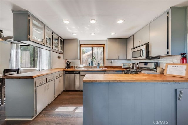 25389 Oak Glen Rd, Twin Peaks, CA 92391 - kitchen with appliances with stainless steel finishes, a peninsula, dark wood finished floors, backsplash, and recessed lighting